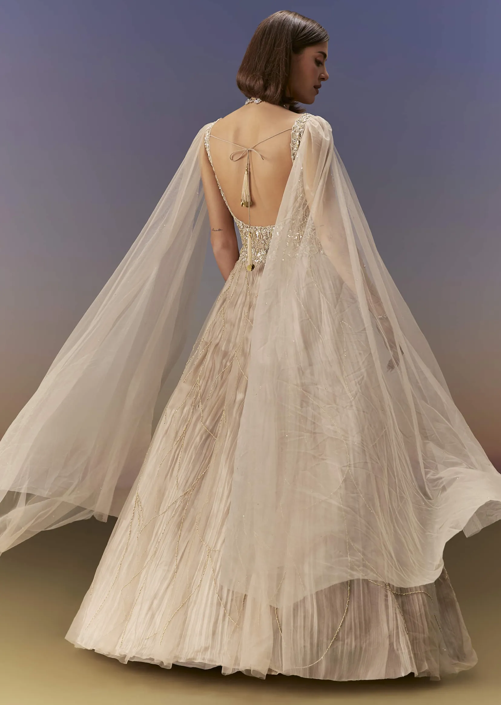 Gold Gown With Pleated Panels And Dramatic Cape