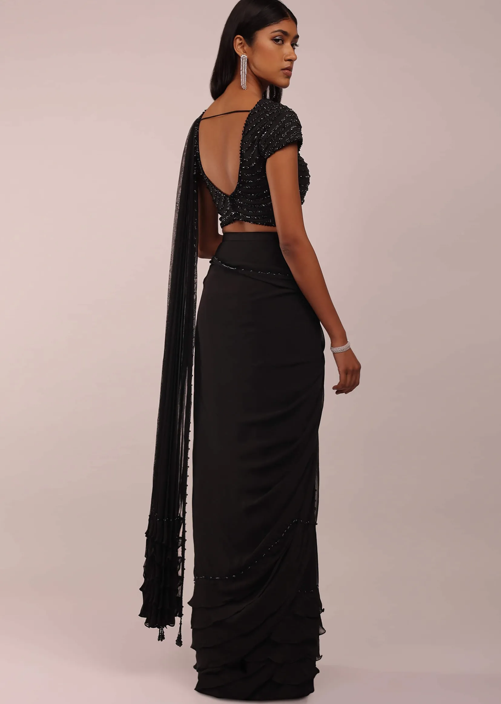 Pitch Black Saree With Three Tones Of Layered Frills On The Bottom Embellished In Stones And Sequins With A Tassel On The Pallu Corner